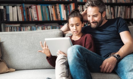 Father and daughter looking at tablet on sofa