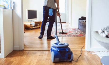 Rear view of man vacuuming carpet